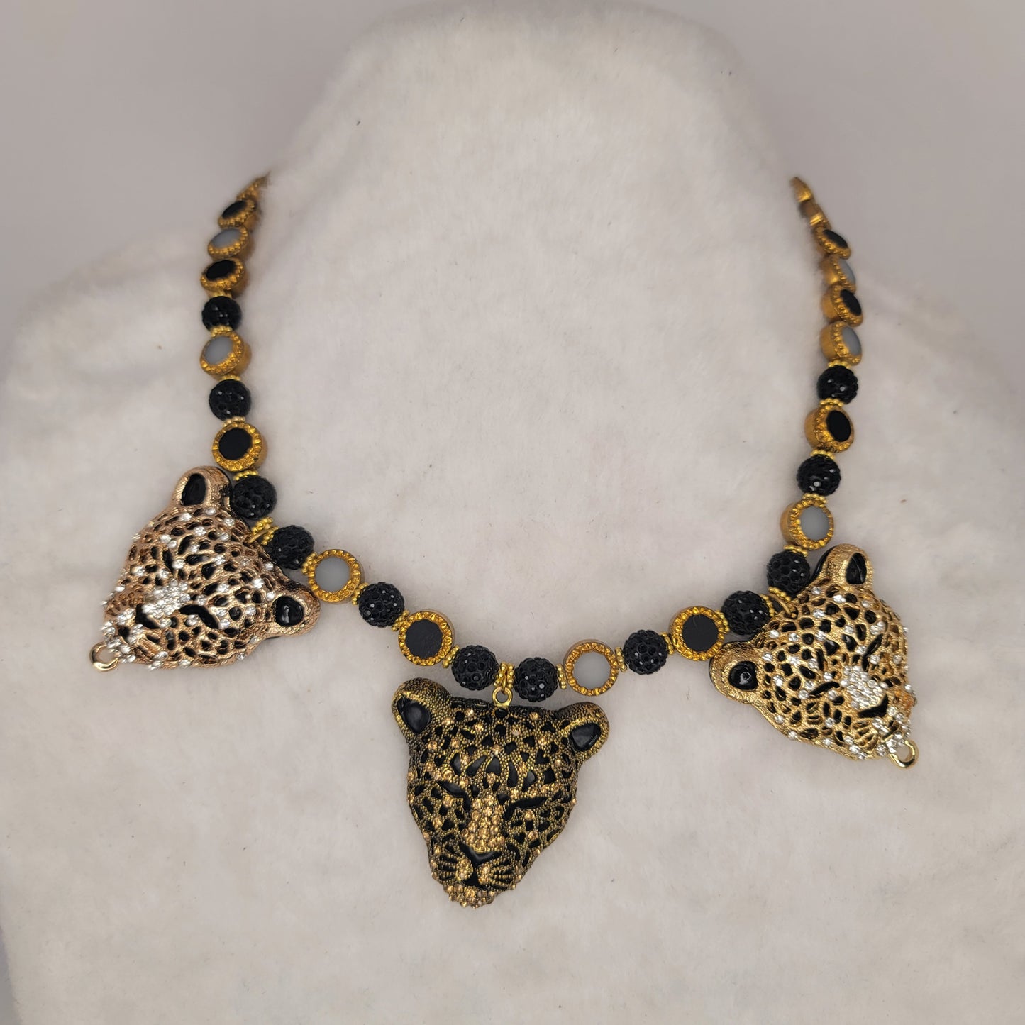 Tri-pendant leopard heads necklace with stainless-steel clasp.