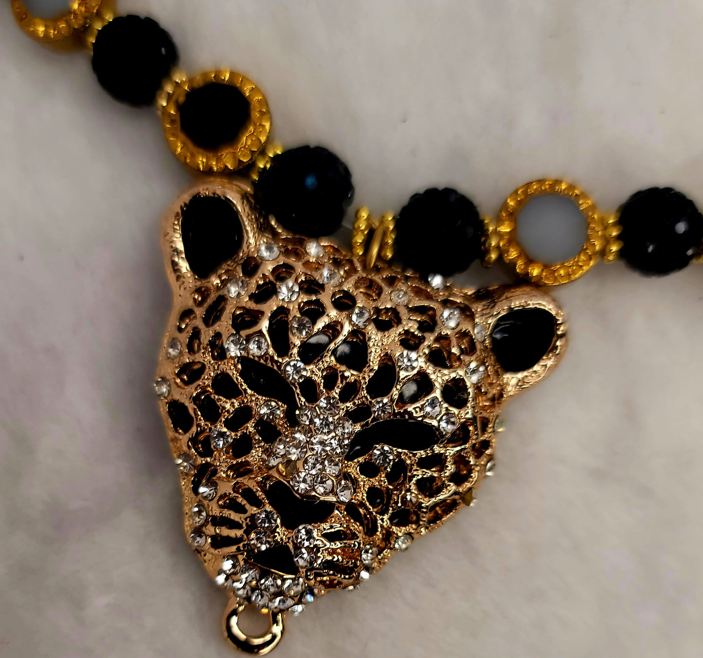 Tri-pendant leopard heads necklace with stainless-steel clasp.