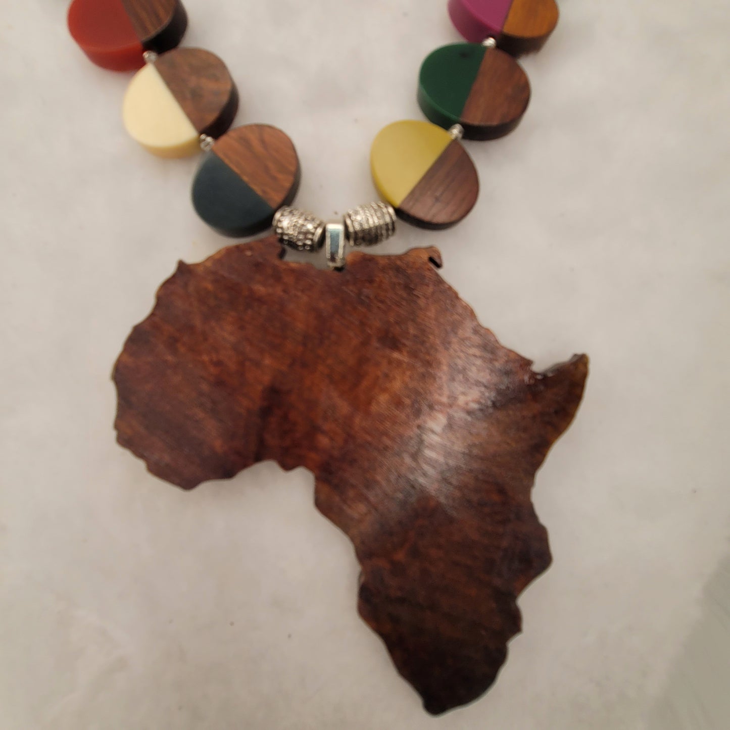 Large wood African Pendant with multi-colored wood and resin necklace with silver tone accent beads.