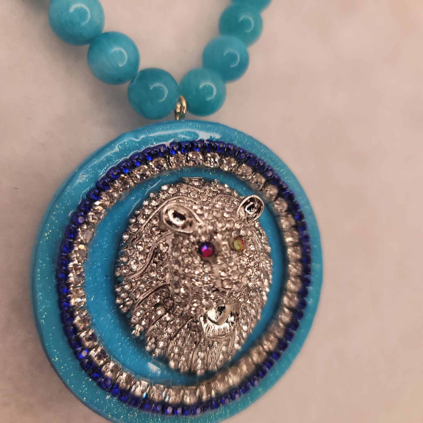 Rhinestone silver plated lion head circle pendant with Aquamarine necklace.