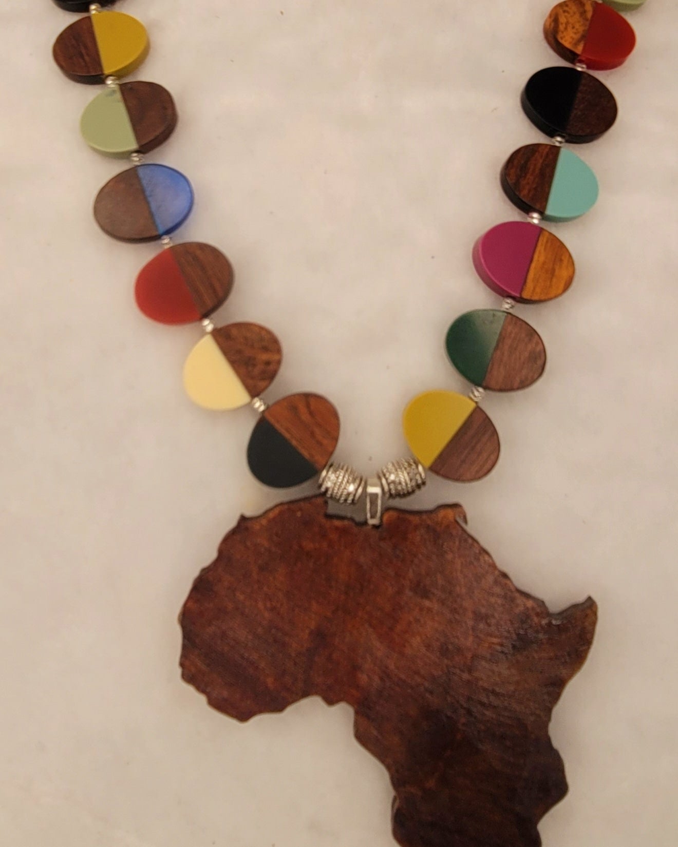 Large wood African Pendant with multi-colored wood and resin necklace with silver tone accent beads.